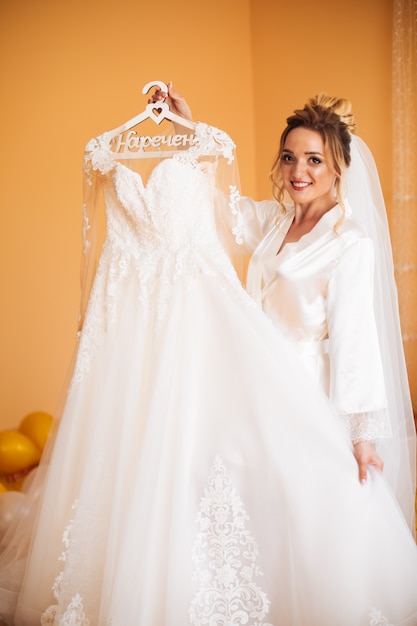 Sposa in vestito bianco che posa mentre preparando per la cerimonia di nozze