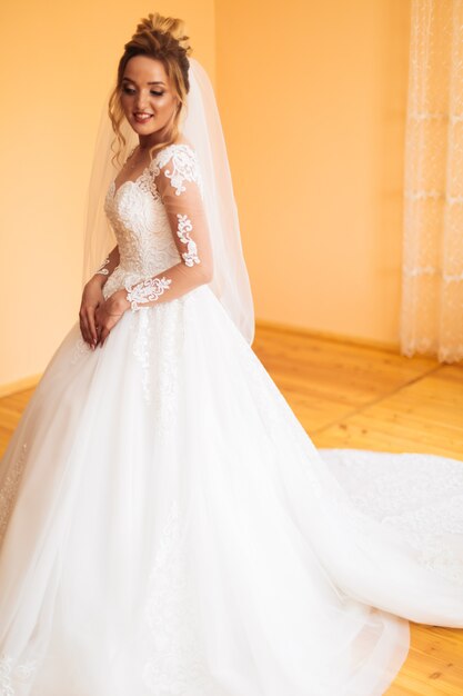 Bride in white dress posing while preparing for the wedding ceremony