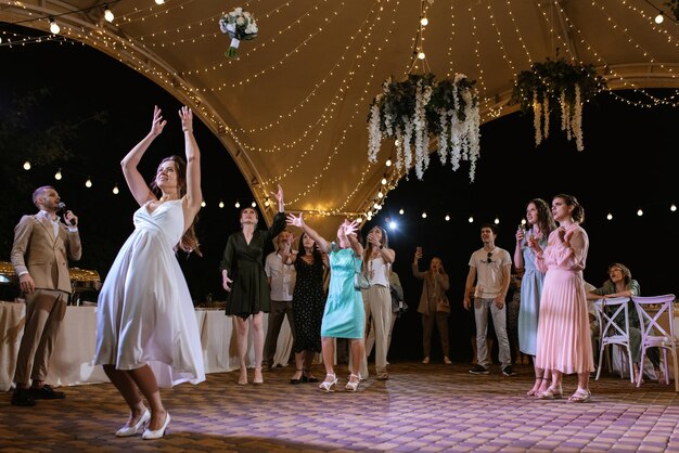 Bride in a white dress throws a wedding bouquet