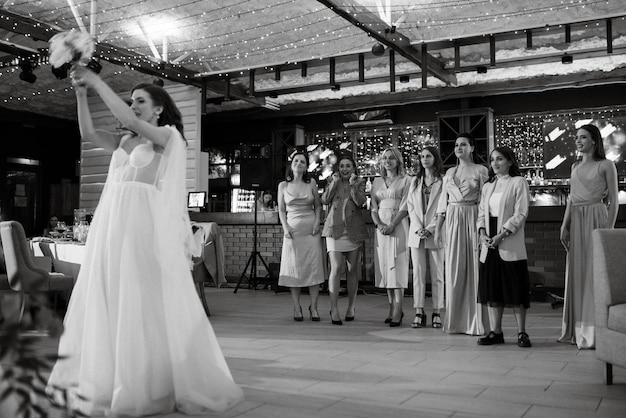 Bride in a white dress throws a wedding bouquet