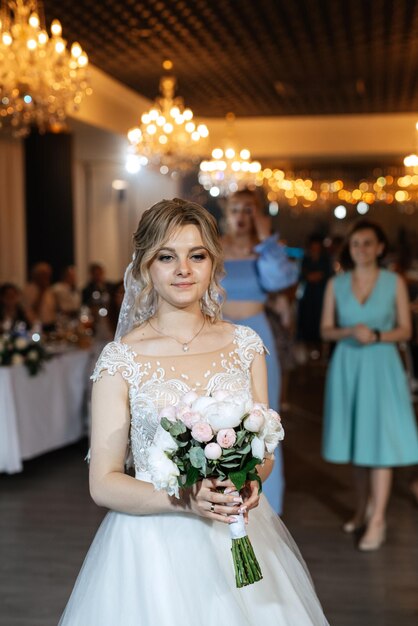 白いドレスを着た新婦が結婚式の花束を投げかける