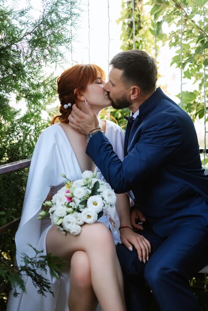 Bride in a white dress with a bouquet and the groom in a blue suit