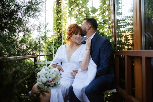 Photo bride in a white dress with a bouquet and the groom in a blue suit