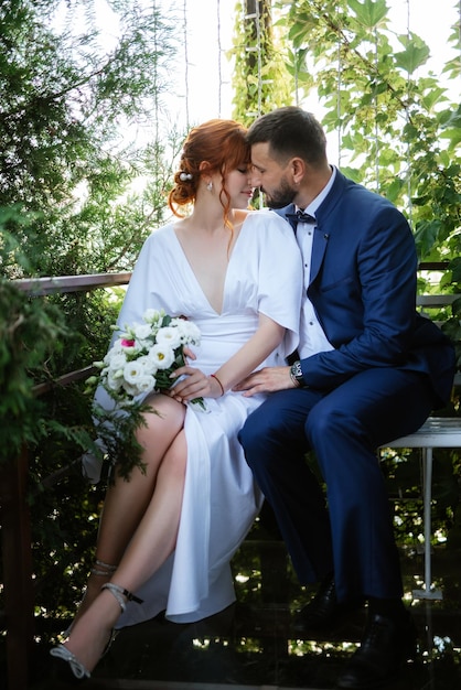 Bride in a white dress with a bouquet and the groom in a blue suit