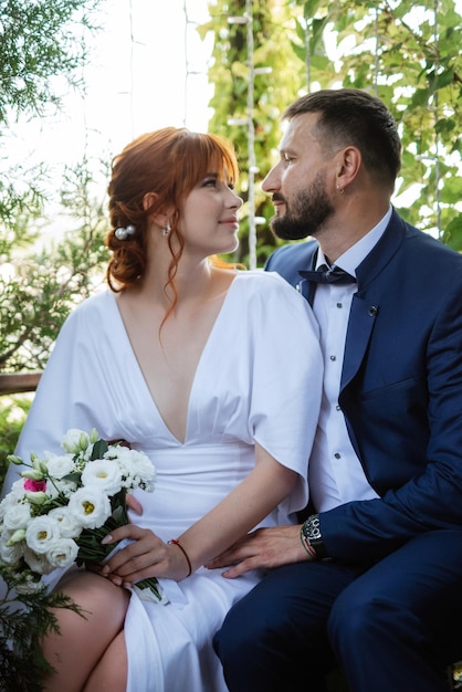 Bride in a white dress with a bouquet and the groom in a blue suit