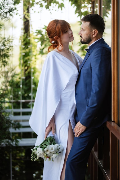 Bride in a white dress with a bouquet and the groom in a blue suit