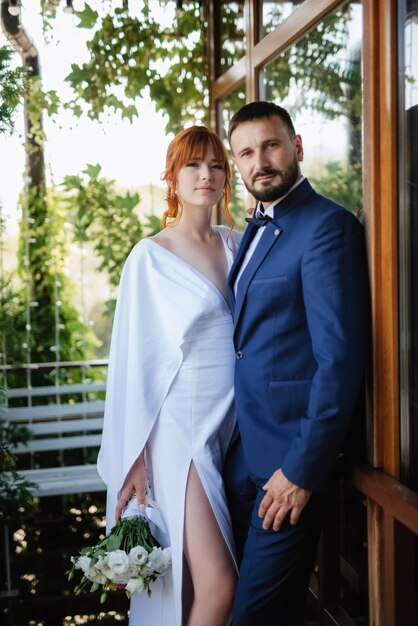 Bride in a white dress with a bouquet and the groom in a blue suit