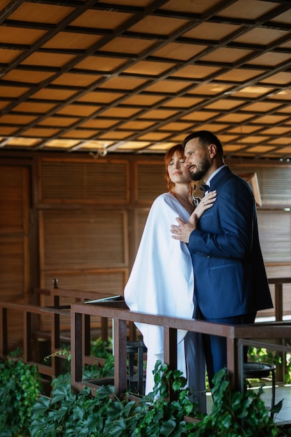 Bride in a white dress with a bouquet and the groom in a blue suit