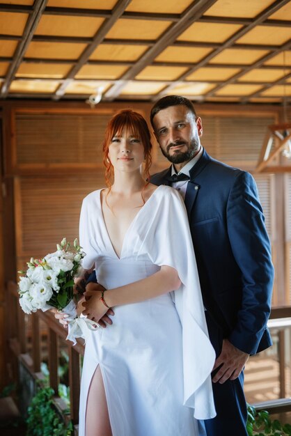 Bride in a white dress with a bouquet and the groom in a blue suit