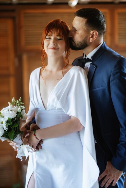 Bride in a white dress with a bouquet and the groom in a blue suit