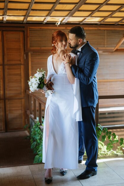 Bride in a white dress with a bouquet and the groom in a blue suit