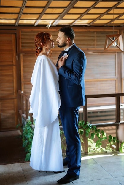 Bride in a white dress with a bouquet and the groom in a blue suit