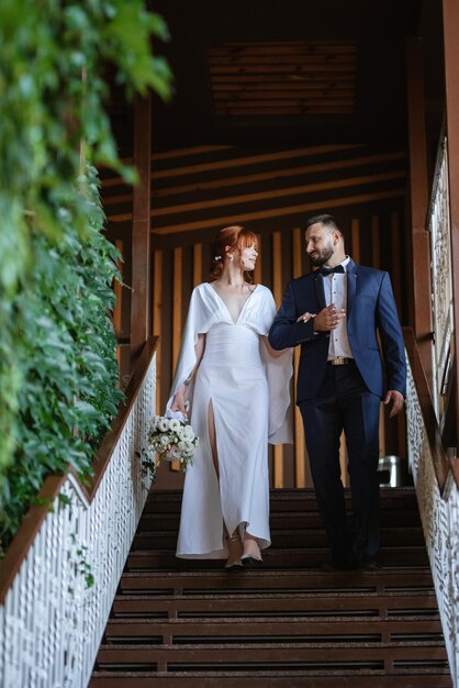 Bride in a white dress with a bouquet and the groom in a blue suit