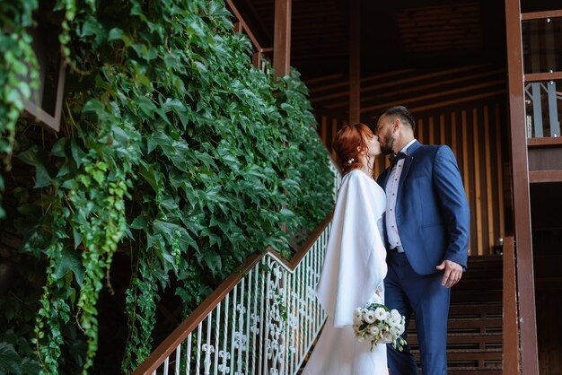 Bride in a white dress with a bouquet and the groom in a blue suit