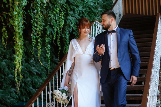 Bride in a white dress with a bouquet and the groom in a blue suit