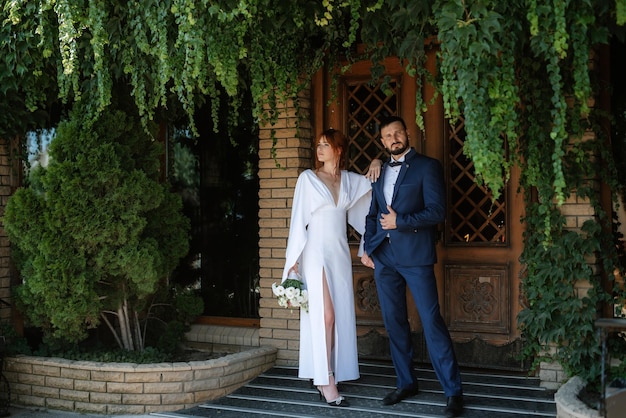 Bride in a white dress with a bouquet and the groom in a blue suit