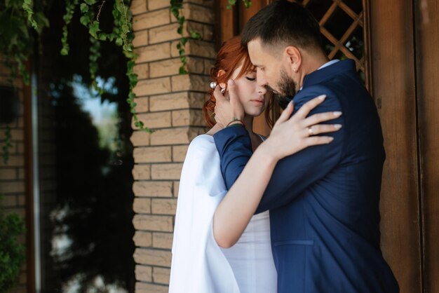 Bride in a white dress with a bouquet and the groom in a blue suit