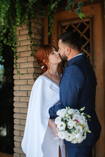 Bride in a white dress with a bouquet and the groom in a blue suit