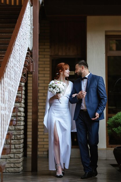 Bride in a white dress with a bouquet and the groom in a blue suit