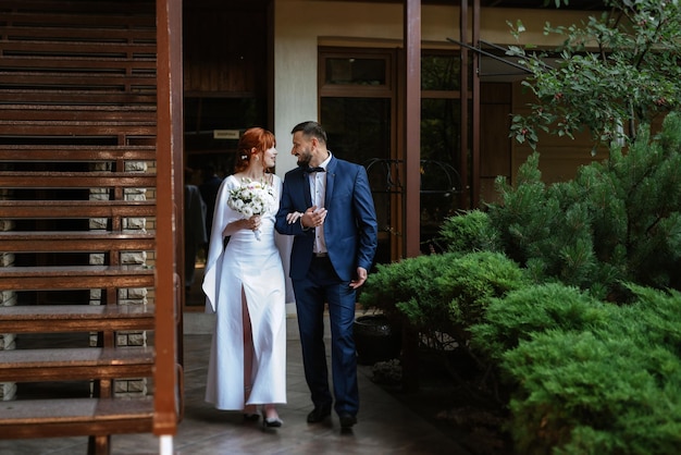 Bride in a white dress with a bouquet and the groom in a blue suit