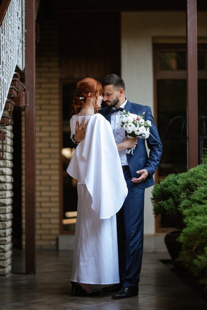 Bride in a white dress with a bouquet and the groom in a blue suit