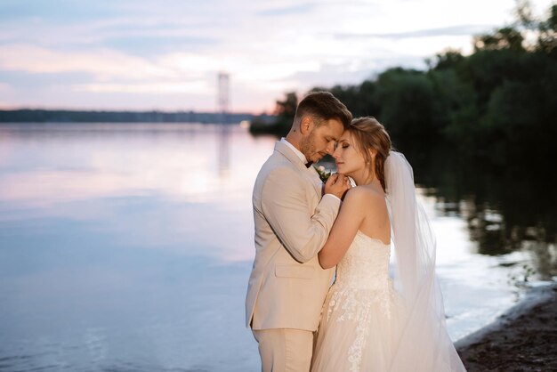 Bride in a white puffy dress and the groom in t on the river bank