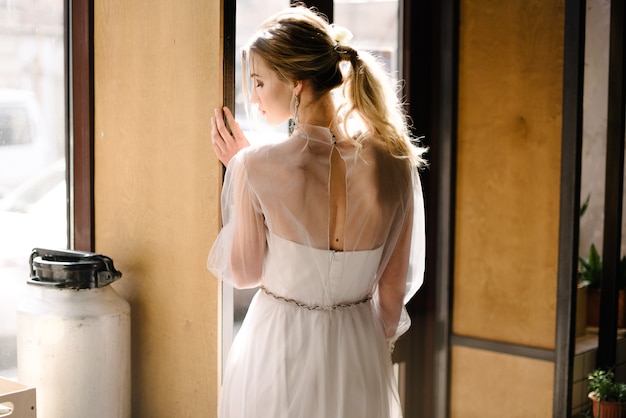 Bride in white wedding dress posing indoors