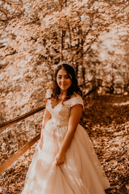 Bride in white wedding dress walks through autumn