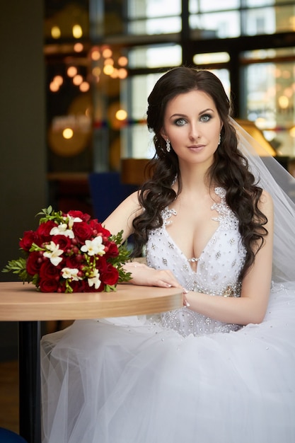 Bride with a bouquet of flowers sitting at table