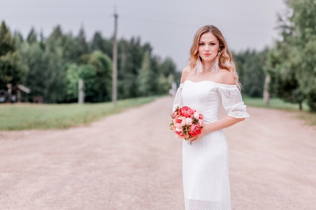 Bride with a bouquet of peonies in her hands