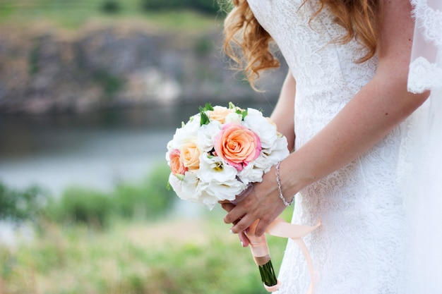 Sposa con bouquet di fiori rosa e bianchi