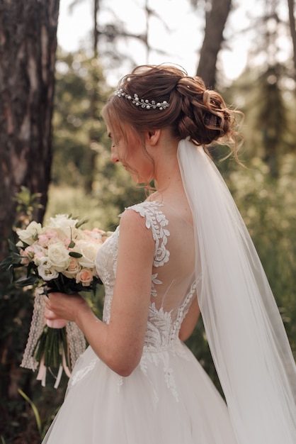 bride with bouquet, white dress and veil