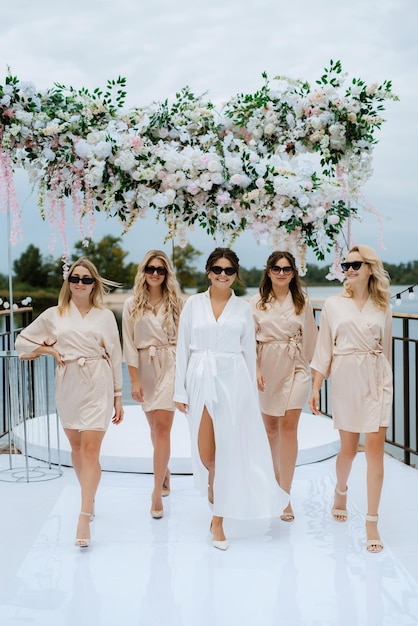 Photo bride with bridesmaids in light dresses before the wedding