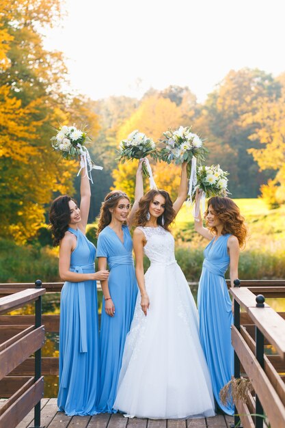 Bride with bridesmaids in the park on the wedding day