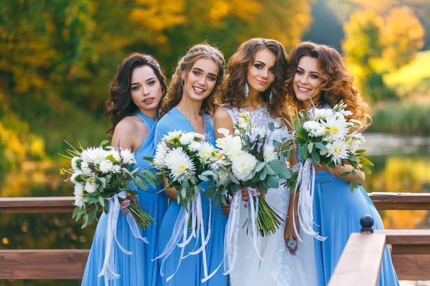 Bride with bridesmaids in the park on the wedding day