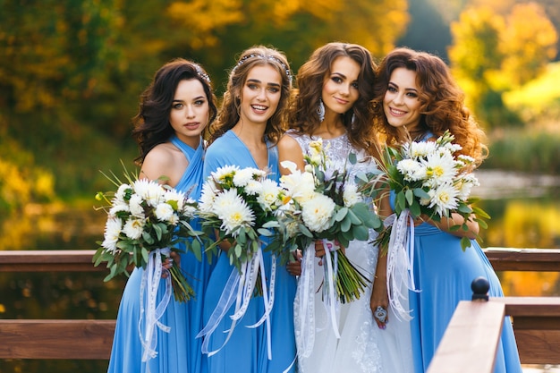 Bride with bridesmaids in the park on the wedding day