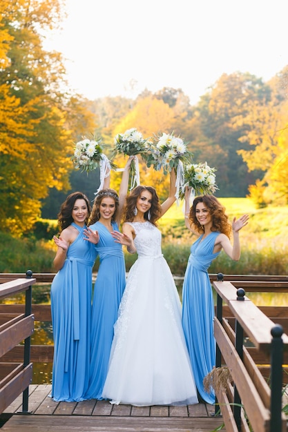 Bride with bridesmaids in the park on the wedding day