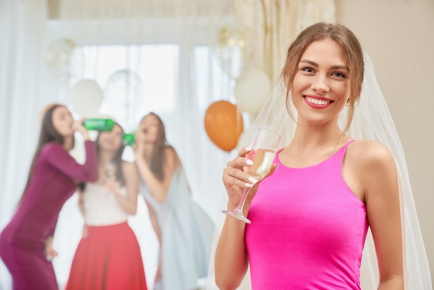 Bride with champagne sitting at home party