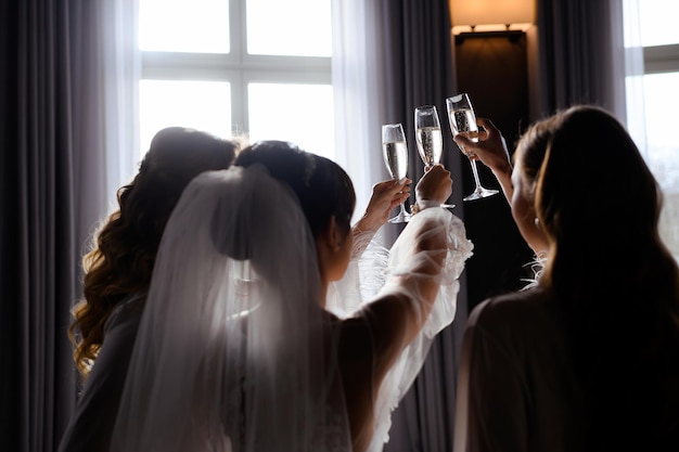 Bride with frieds clinking glasses