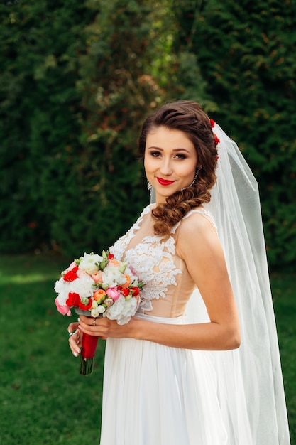 Bride with wedding bouquet in elegant wedding dress looks