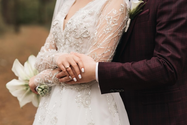 The bride with a white wedding bouquet holds the groom's hand the wedding ceremony