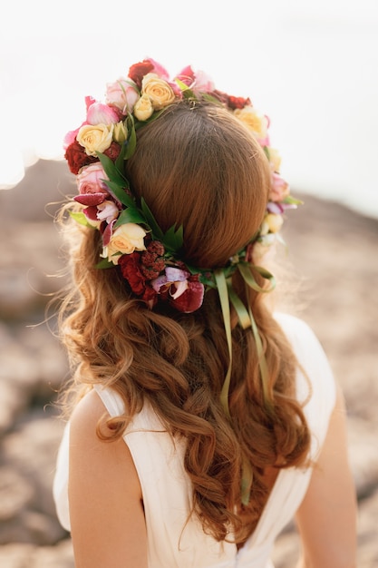 Bride with a wreath of roses on her head back view a flower wreath on the head of a girl for brown