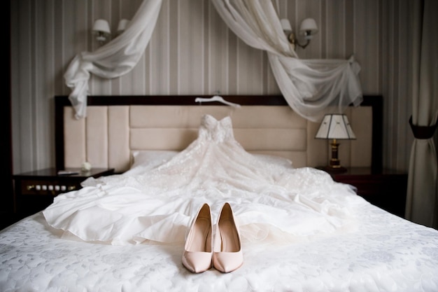 Bride39s trouwschoenen en trouwjurk op het bed