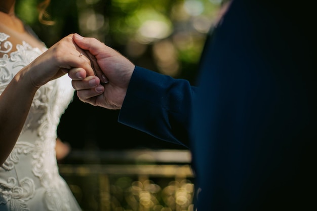 花婿は花嫁の手を握ります。クローズアップ写真。ソフト フォーカス