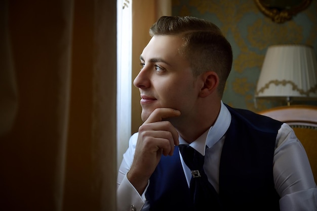 Photo bridegroom looking away while sitting at home