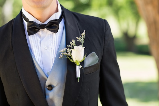 Bridegroom wearing boutonniere in garden