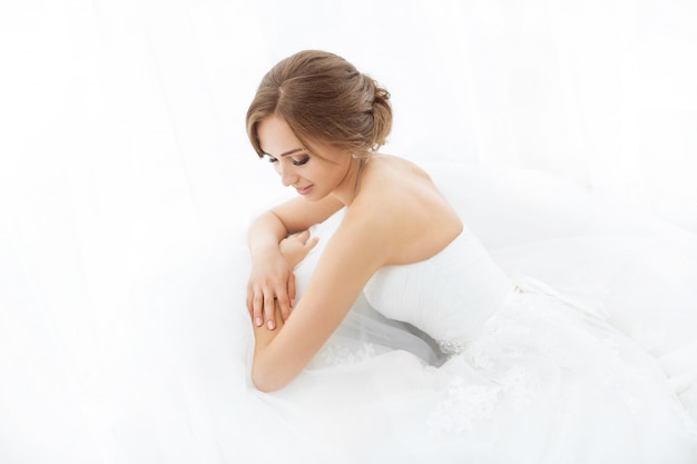 Brides beauty. Young woman in wedding dress indoors