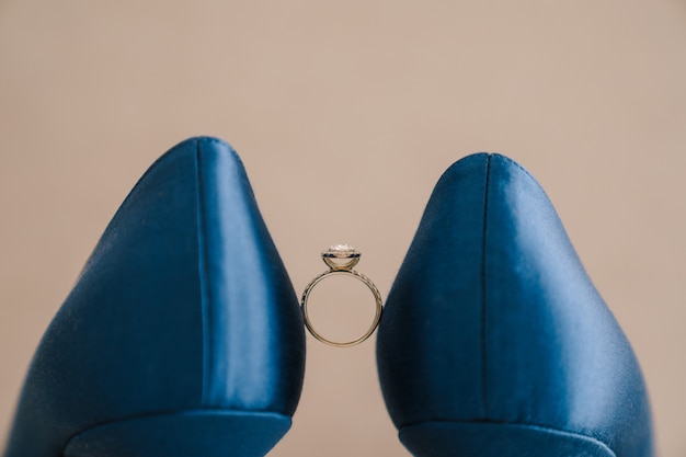 Brides engagement ring with a gem between blue shoes