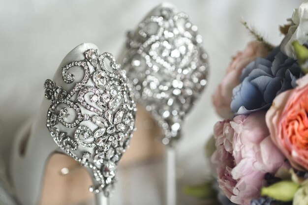 Brides wedding shoes with a bouquet with roses