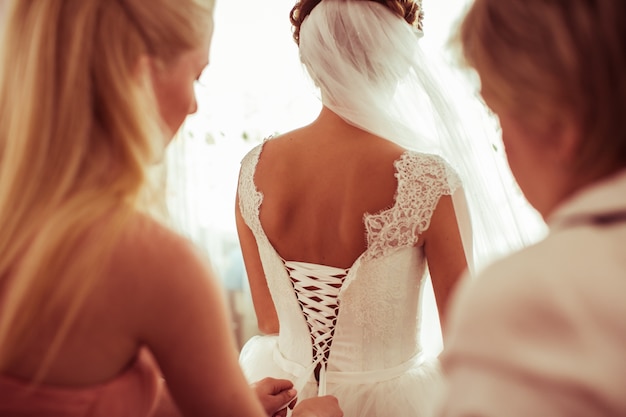 Bridesmaid climbing the zipper of a wedding dress